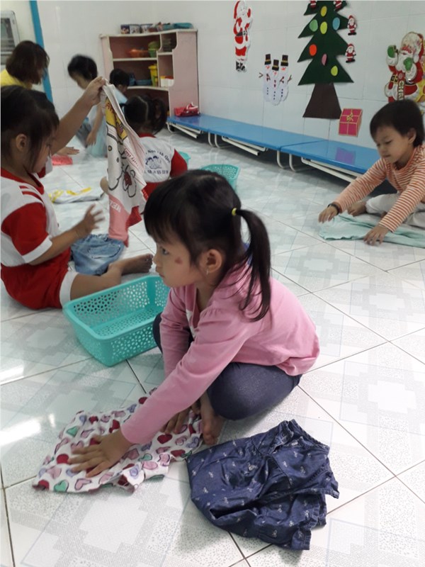 Trẻ lớp Mầm 2 thực hành xếp quần áo.
